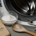 Nettoyer machine à laver bicarbonate de soude, bol de bicarbonate et chiffon devant le lave-linge